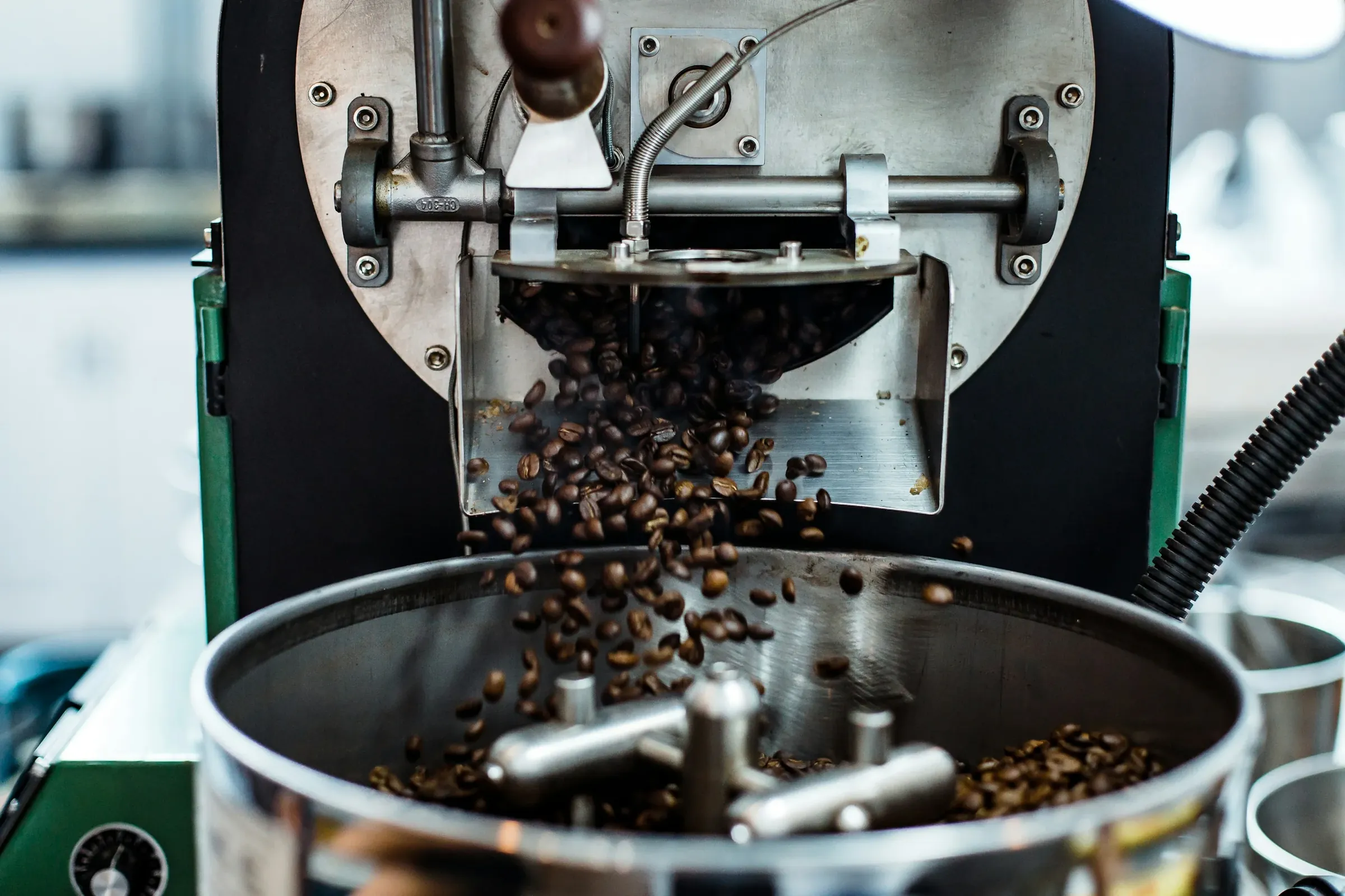 Vers gebrande koffiebonen die uit de brander komen