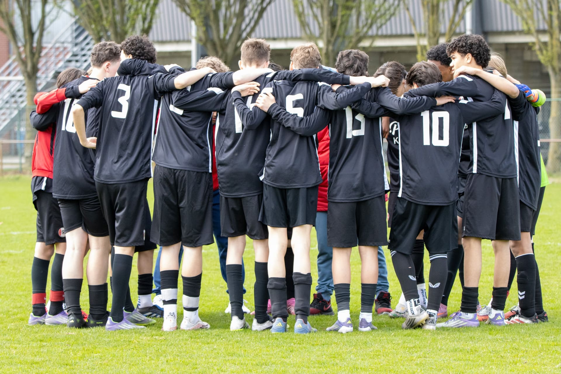 Youth soccer team in a huddle on the pitch just before kick-off, on a Sports Tourz trip